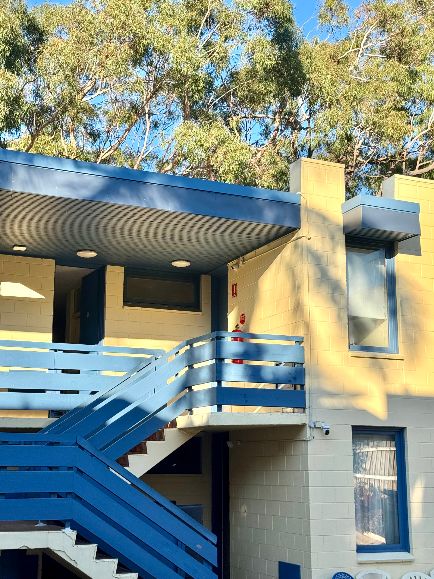 Blue balcony stairs and yellow brick facade